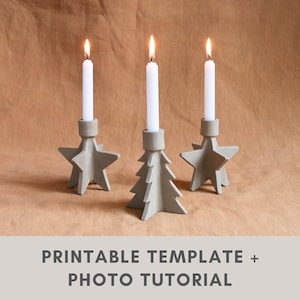 May include: Three concrete candle holders with lit white candles. Two are star-shaped, and one is a Christmas tree shape. The candle holders are grey and sit on a brown surface. The text "PRINTABLE TEMPLATE + PHOTO TUTORIAL" is at the bottom.
