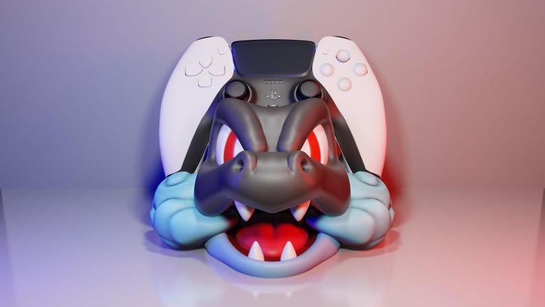 Może przedstawiać: Niestandardowe akcesorium do konsoli do gier z wystylizowanym wzorem głowy smoka. Smok jest gł&oacute;wnie ciemnoszary z czerwonymi oczami, białymi zębami i jasnoniebieskimi akcentami. Akcesorium jest połączone z białym i czarnym kontrolerem do gier.