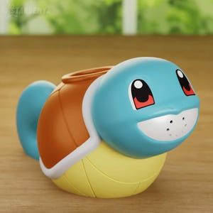 以下が含まれることがあります： 青と茶色のスquirtleのポケモンキャラクターのフィギュア。フィギュアはプラスチック製で、黄色の腹をしています。フィギュアはポケモンフランチャイズの人気キャラクターです。