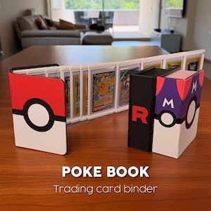 Puede incluir: Un archivador de cartas coleccionables con un dise&ntilde;o de Pokeball rojo y blanco, un dise&ntilde;o negro y rojo Team Rocket y un dise&ntilde;o morado y blanco. El archivador est&aacute; abierto, mostrando cartas coleccionables. El texto "POKE BOOK Trading card binder" est&aacute; en la parte inferior.