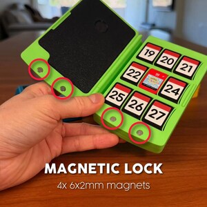 May include: A green magnetic lock case with a black interior and a series of numbered compartments. The case is open, revealing the interior and the magnetic closures. The text "MAGNETIC LOCK" and "4x 6x2mm magnets" are displayed.