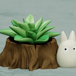 May include: A small, white, cartoon character with large eyes sits next to a brown tree stump planter with a green succulent plant.