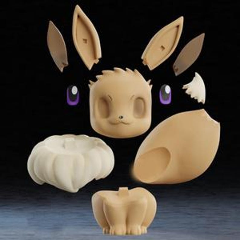 May include: An exploded view of an Eevee figure, showcasing its individual components. The figure is primarily beige, with purple eyes and white accents. The parts include the head, ears, body, and a fluffy collar, all arranged against a dark background.
