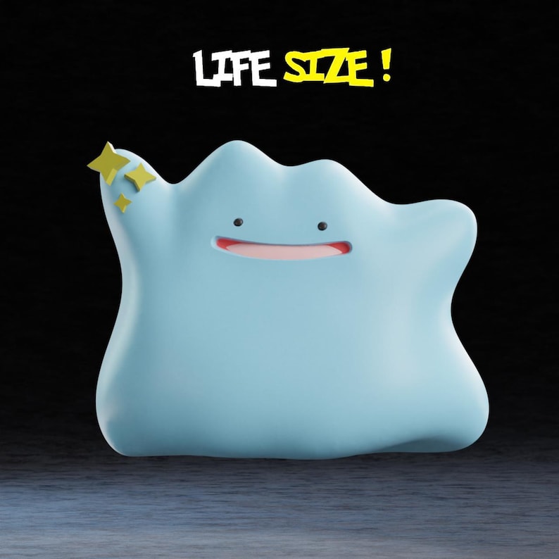 May include: A light blue, blob-shaped figure with a smiling red mouth and small black eyes. The figure has a yellow star-shaped accessory on its upper left side. The words "LIFE SIZE!" are above the figure.
