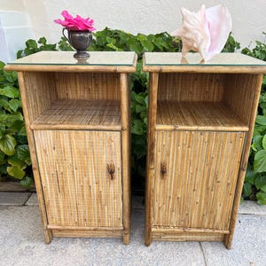 May include: A pair of matching rectangular nightstands constructed from natural bamboo and rattan. Each unit features a flat glass top, an open storage shelf at the top, and a single cabinet door below with a small wooden handle for access.
