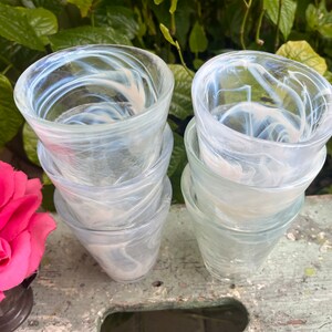 May include: Set of six clear glass tumblers with a swirling white pattern. The glasses are stacked in two groups of three.