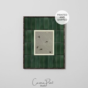 May include: A framed print featuring a postage stamp design with swallows in flight against a gray background. The frame is dark green with a grid pattern. The text "PRINTED AND SHIPPED" is in a white circle. The artist's signature is at the bottom.