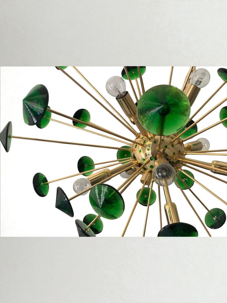 May include: A mid-century modern chandelier with a starburst design. It features gold-toned metal arms extending from a central sphere, adorned with green glass accents and light bulbs. The design is a striking combination of geometric shapes and vibrant color.