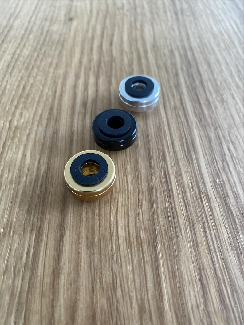 May include: Three round turntable slipmats with different colored rings. The slipmats are gold, black, and silver.