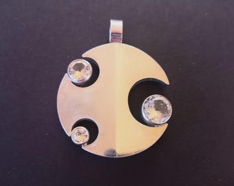 May include: A silver pendant featuring a crescent moon design with three clear gemstones.