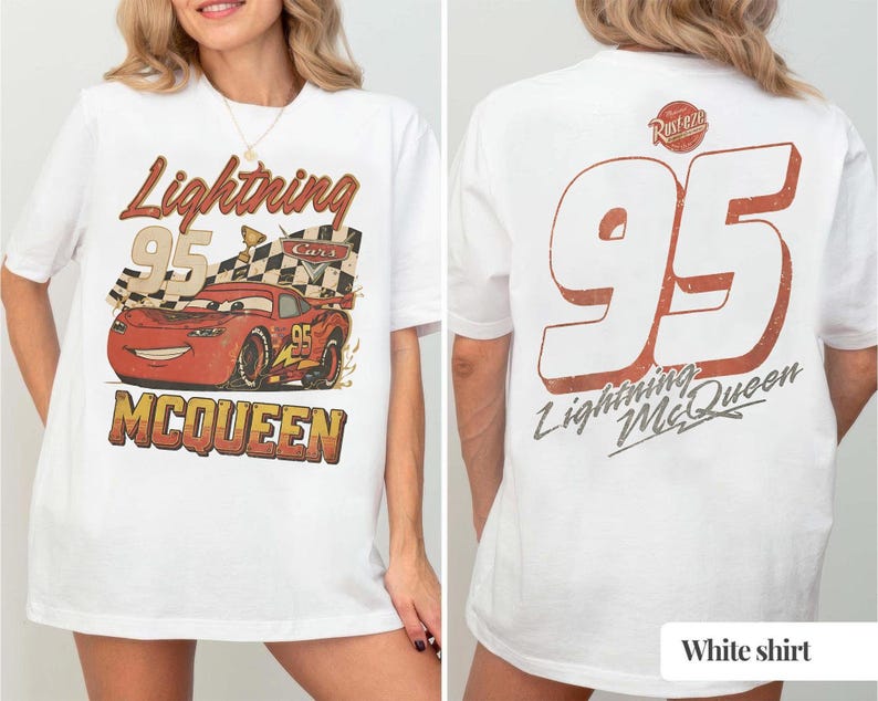 K&ouml;nnte beinhalten: Wei&szlig;es T-Shirt mit einem Front-Grafik von Lightning McQueen aus dem Film Cars, mit dem Text "Lightning McQueen 95". Auf der R&uuml;ckseite des Shirts ist eine gro&szlig;e "95" und der Text "Lightning McQueen" zu sehen.