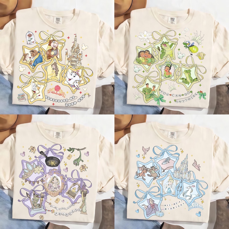 May include: Four cream-colored t-shirts with different Disney-themed designs. Each shirt features a unique arrangement of cartoon characters and elements within star-shaped frames, tied with ribbons. The designs include characters from Beauty and the Beast, Princess and the Frog, Rapunzel, and Cinderella.