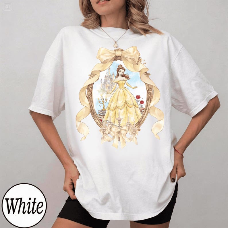 Puede incluir: Camiseta blanca con una ilustraci&oacute;n en acuarela de una mujer con un vestido amarillo dentro de un marco dorado con un lazo. El marco incluye un castillo y rosas rojas. La palabra "White" est&aacute; en un c&iacute;rculo blanco en la parte inferior.