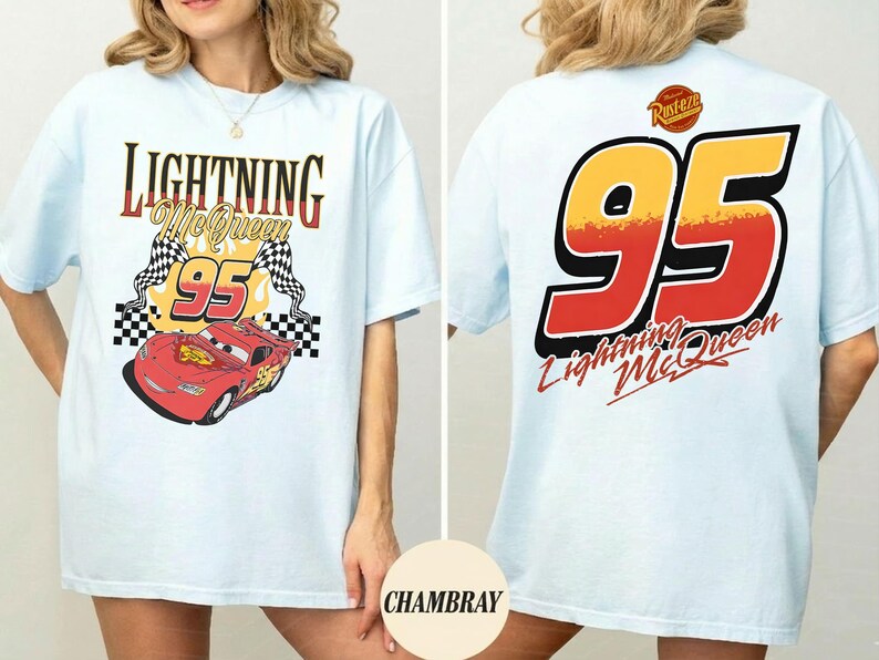 以下が含まれることがあります： ライトブルーのTシャツ。前面には「Lightning McQueen 95」の文字と赤いレーシングカー、チェッカーフラッグが描かれています。背面には、赤と黄色の大きな「95」と「Lightning McQueen」の文字がプリントされています。