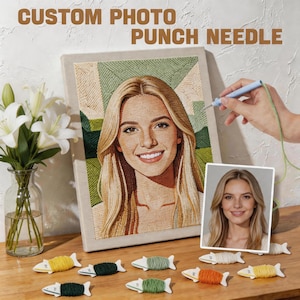 Op de afbeelding: Een aangepast foto-punch needle kunstwerk met een portret van een blonde vrouw. Het kunstwerk wordt getoond op een canvas, met een punch needle tool en kleurrijke garenspoelen. De tekst "CUSTOM PHOTO PUNCH NEEDLE" staat bovenaan.