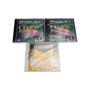 Puede incluir: Tres discos CD-RW y CD-R en su embalaje original. Se ven dos discos Memorex CD-RW Platinum 650 y un disco Maxell CD-R74. El embalaje es de plástico transparente con detalles en negro y amarillo.
