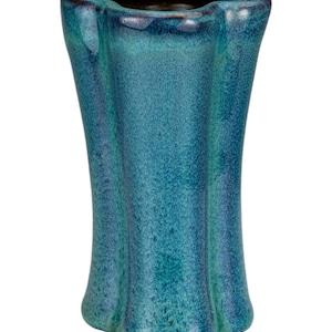May include: A teal-colored ceramic vase with a unique, wavy rim and a textured surface. The vase has a flared shape and a dark interior, suitable for displaying flowers or as a decorative piece. The glaze has a speckled appearance.