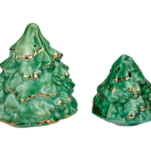 Könnte beinhalten: Zwei Salz- und Pfefferstreuer in Form von Weihnachtsbäumen aus Keramik. Die Bäume sind leuchtend grün mit goldenen Zierleisten. Der größere Baum ist etwa 10 cm hoch, der kleinere etwa 8 cm. Auf weißem Hintergrund.