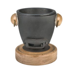 May include: A dark gray, cast iron-style container with a wooden base and accents. The container has a rounded shape with a circular opening at the top. Two wooden knobs are attached to the sides. The container sits on a round wooden base.