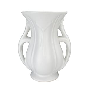 May include: A matte white ceramic vase featuring a wide, flared rim and a bulbous body with vertical embossed ridges. The vessel includes two symmetrical, arched handles that connect the upper neck to the lower section of the rounded base.