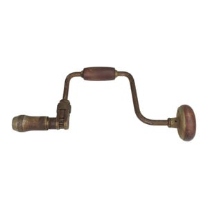 May include: A vintage hand brace drill featuring a rusted metal crank frame, a dark brown wooden handle at the center, a matching wooden knob at the end, and a metal chuck mechanism with a textured grip surface for holding drill bits securely.