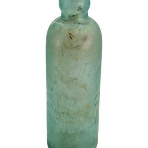 May include: A vintage light aqua glass bottle with a rounded top and a cylindrical body. The glass features embossed lettering that reads GALLAHER & CO PHILADA, showing signs of age with surface wear and subtle discolouration on the exterior.