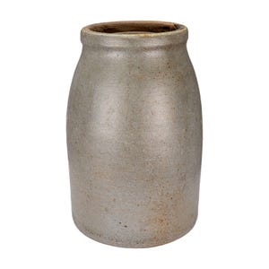 May include: A gray stoneware crock with a slightly tapered cylindrical shape. The antique jar has a wide mouth and a rounded rim. The exterior has a mottled, aged appearance, suggesting it is an antique or vintage piece. The crock is likely used for storage or decoration.