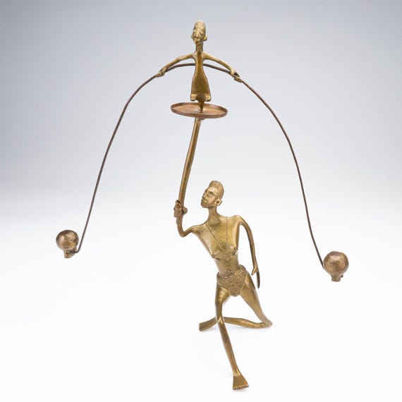 Solid brass Benin-style acrobat that actually balances and sways — kinetic folk art with real cultural weight and desk-presence.