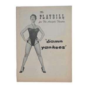 Puede incluir: Portada de programa de teatro vintage para "Damn Yankees" en el Teatro Adelphi. La portada presenta una imagen en blanco y negro de una mujer con un body negro y tacones. El título y el nombre del teatro están impresos en negro.