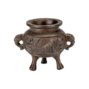 May include: A bronze incense burner with three legs and two handles. The burner has detailed floral and bird relief carvings around the body. The top has a wide opening for incense. The design is ornate and traditional.