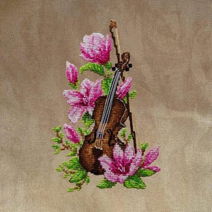 May include: A brown violin with a bow is surrounded by pink magnolia flowers with green leaves. The flowers and violin are embroidered on a beige fabric.