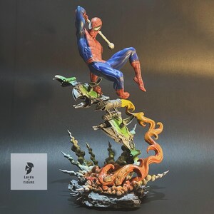 Op de afbeelding: Een rood en blauw Spiderman-actiefiguur is in de lucht geposeerd, zwaaiend aan een web, op een groen en grijs ruimteschip-achtig voetstuk. Het voetstuk is omgeven door oranje en gele vlammen en groen en grijs gebladerte.