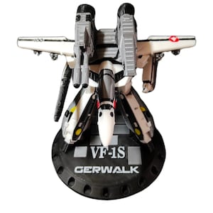Puede incluir: Modelo impreso en 3D de un VF-1S Gerwalk, un caza transformable de la serie de anime Macross. El modelo es principalmente blanco, negro y gris, con detalles en rojo y amarillo. El modelo está montado sobre una base negra con el texto "VF-1S GERWALK".
