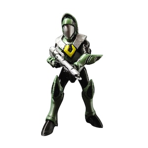 Puede incluir: Una pequeña figura de un soldado futurista con un traje blindado verde y negro, sosteniendo un rifle plateado. La figura tiene un casco plateado y un emblema amarillo en el pecho. El diseño sugiere ciencia ficción o fantasía.