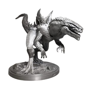 Könnte beinhalten: Ein silberfarbenes 3D-gedrucktes Modell einer großen, reptilienartigen Kreatur mit scharfen Zähnen und Krallen. Die Kreatur steht auf einem runden Sockel mit einer strukturierten Oberfläche.