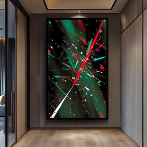 May include: Abstract art print featuring a dynamic composition of red, green, and white lines against a dark background. The artwork has a modern, energetic feel, with a mix of sharp angles and scattered light effects. The piece is framed in black.