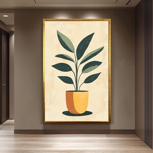 Peut inclure: Une impression botanique encadrée représentant une plante stylisée dans un pot jaune. La plante a de grandes feuilles vert foncé sur un fond beige. Le cadre est doré et l'œuvre est exposée dans un couloir.