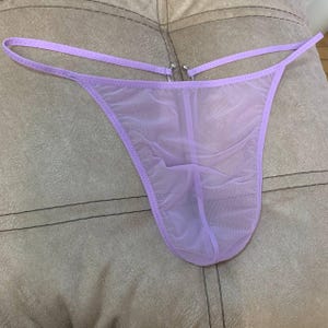Può includere: Un perizoma trasparente color lavanda con spalline delicate e rifiniture abbinate. La biancheria intima presenta un design minimalista con un tessuto morbido e trasparente. Il perizoma è progettato per il comfort e una sensazione di leggerezza.