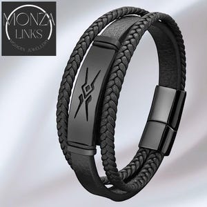 Può includere: Bracciale in pelle nera con un design intrecciato e una placca rettangolare in metallo nero con un design geometrico. Il bracciale ha una chiusura magnetica. Il logo Monza Links si trova nell'angolo in alto a sinistra.