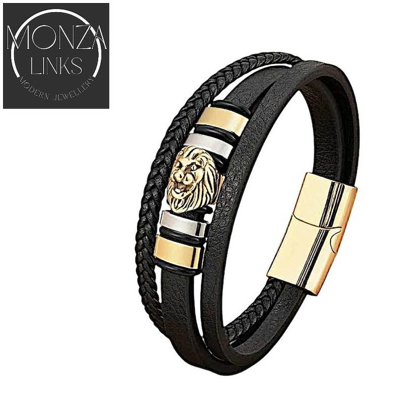 May include: Black leather bracelet with a gold lion head charm and gold metal accents.  Monza Links Modern Jewellery.