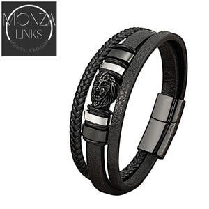 May include: Black leather bracelet with a silver and black lion head charm. The bracelet is made of three strands of leather and has a magnetic clasp.