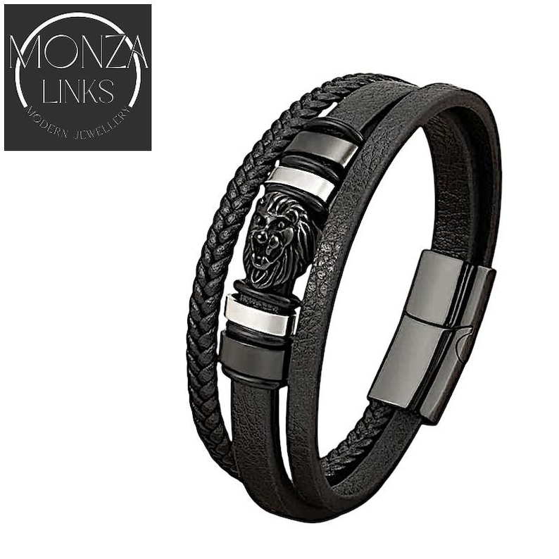 May include: Black leather bracelet with a silver and black lion head charm. The bracelet is made of three strands of leather and has a magnetic clasp.