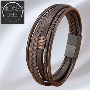May include: A brown leather bracelet with multiple strands and a magnetic clasp. The bracelet has braided and smooth leather strands, with a copper-coloured accent. The brand name "MONZA LINKS MODERN JEWELLERY" is in the upper left corner.