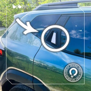 Può includere: Un'auto color teal con finiture nere e un portapacchi nero. L'immagine evidenzia un accento bianco sul finestrino posteriore dell'auto. È visibile un adesivo circolare con la scritta "BOBLAB ORIGINAL PRODUCT ONLY".