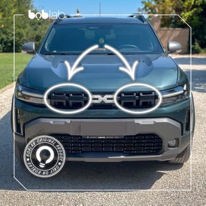 Puede incluir: Vista frontal de un SUV verde oscuro con una parrilla negra que presenta dos secciones rectangulares resaltadas por flechas y círculos blancos. El vehículo muestra el logotipo de boblab en la esquina superior izquierda y un emblema circular.