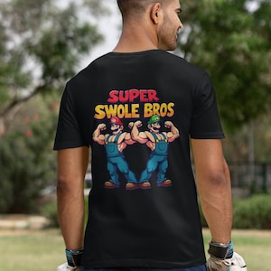 May include: Black t-shirt featuring a graphic of two muscular cartoon figures with the text "Super Swole Bros."