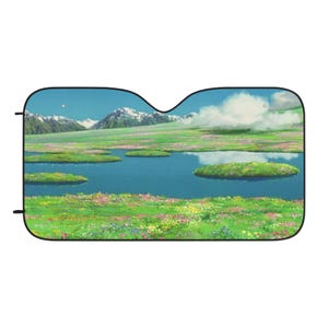 May include: A car sunshade featuring a scenic landscape with a blue lake, green islands, and snow-capped mountains under a blue sky. The design includes colorful flowers and a bright, sunny atmosphere.