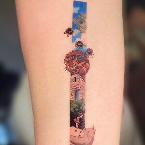 K&ouml;nnte beinhalten: Ein Tattoo, das eine Szene aus dem Animationsfilm 'Mein Nachbar Totoro' zeigt. Das Tattoo zeigt einen fliegenden Katzenbus, ein junges M&auml;dchen und mehrere Ru&szlig;geister.