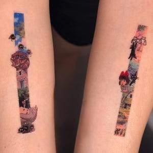 K&ouml;nnte beinhalten: Zwei Tattoos auf den Armen einer Person. Der linke Arm hat ein Tattoo einer Szene aus dem Film "Howls bewegliches Schloss" mit dem Schloss, einer schwarzen Katze und einem M&auml;dchen. Der rechte Arm hat ein Tattoo einer Szene aus dem Film "Kikis kleiner Lieferservice" mit Kiki und ihrer schwarzen Katze Jiji.