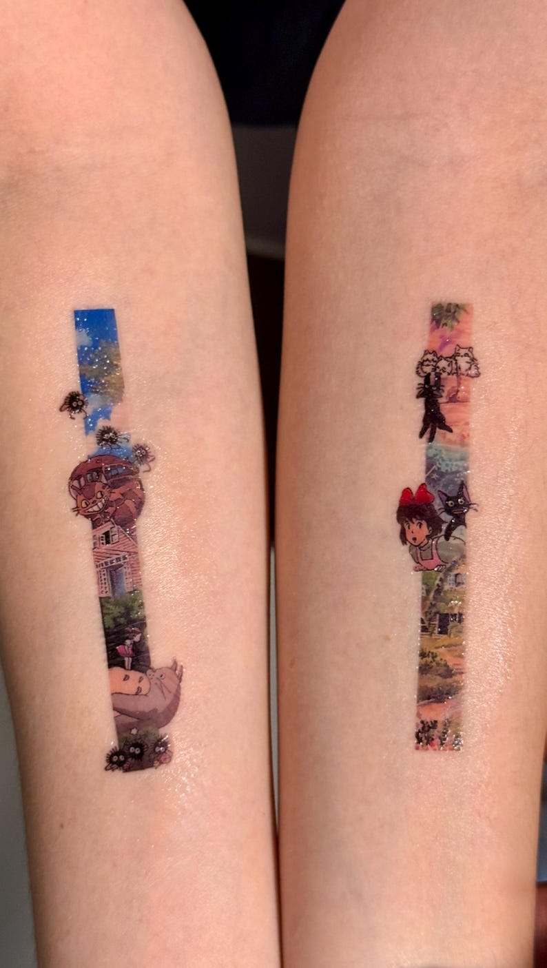 K&ouml;nnte beinhalten: Zwei Tattoos auf den Armen einer Person. Der linke Arm hat ein Tattoo eines fliegenden Hauses mit einer Katze oben drauf, umgeben von kleinen schwarzen Kreaturen. Der rechte Arm hat ein Tattoo eines M&auml;dchens mit einer Katze, umgeben von einer bunten Landschaft.